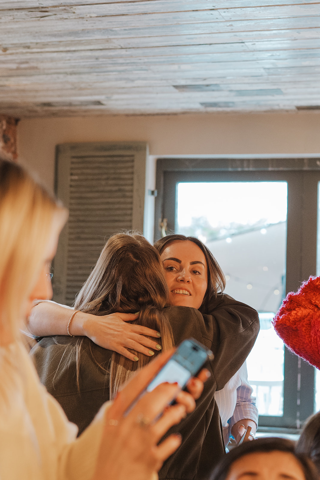 Two women hugging hello at the start of a catch-up